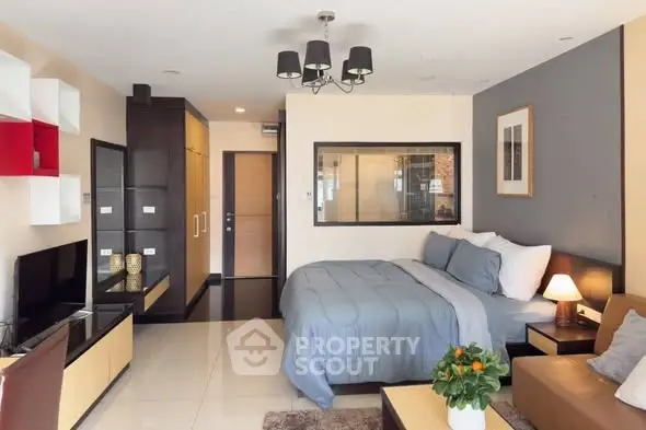 Modern studio apartment with stylish decor and cozy ambiance, featuring a comfortable bed and sleek furniture.