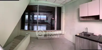 Spacious interior with modern kitchenette and large window view.