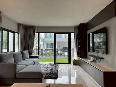 Spacious modern living room with large windows and sleek furniture