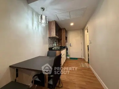 Cozy kitchen with dining area featuring modern lighting and wooden flooring.