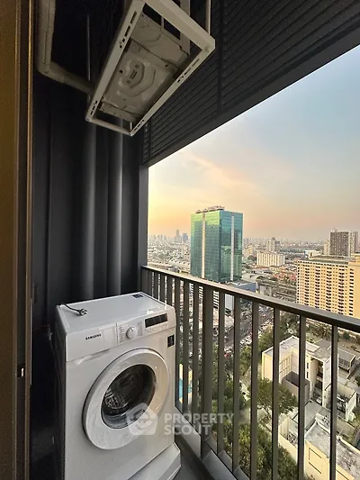 High-rise balcony with washing machine and stunning city view at sunset.