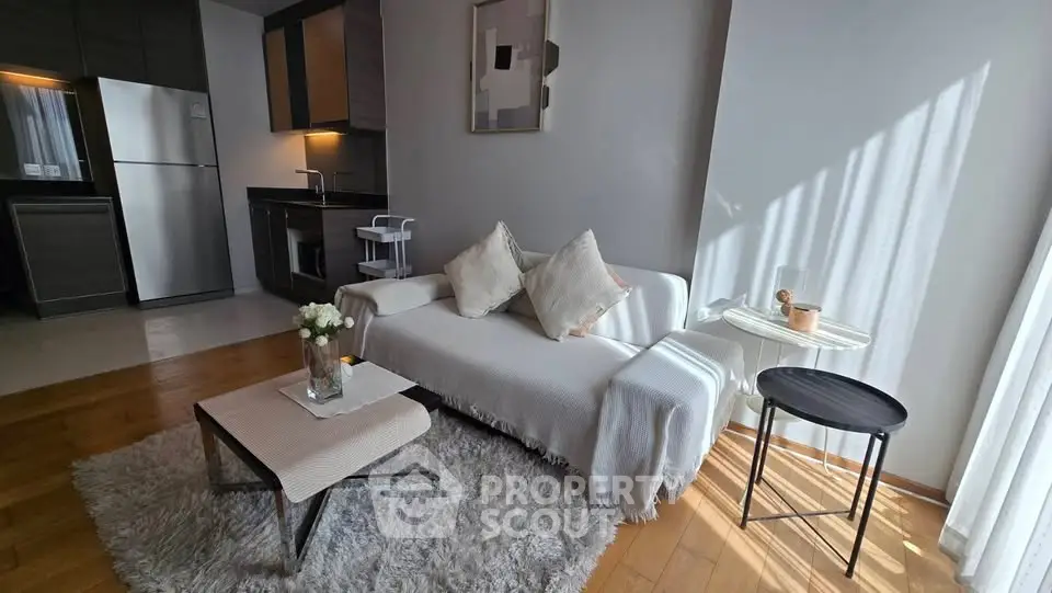 Modern living room with cozy sofa, stylish decor, and open kitchen layout in a bright apartment.