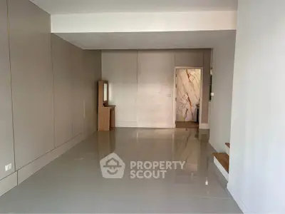 Spacious modern living room with glossy tiled floors and minimalist design