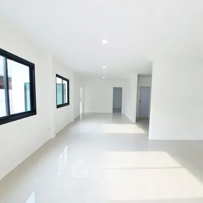 Spacious and bright empty room with large windows and glossy floor tiles.
