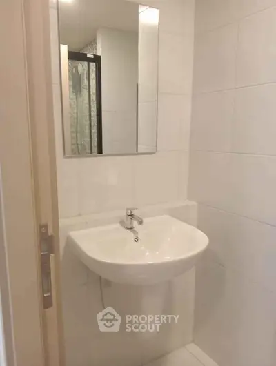 Modern bathroom with sleek white sink and mirror, ideal for contemporary living.