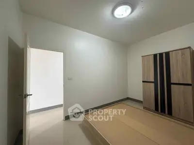 Minimalist bedroom with wooden wardrobe and bed frame, ideal for modern living.