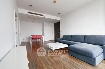 Spacious modern living room with sleek wooden flooring and stylish furniture