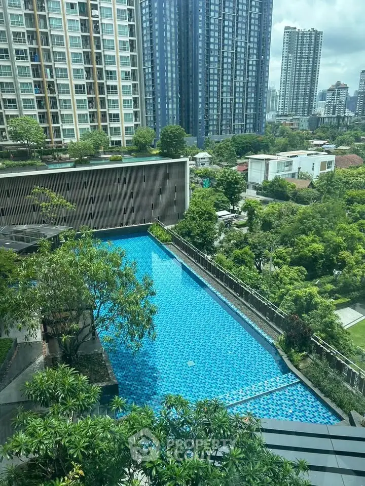 Luxurious high-rise apartment with stunning pool view and lush greenery in urban setting.