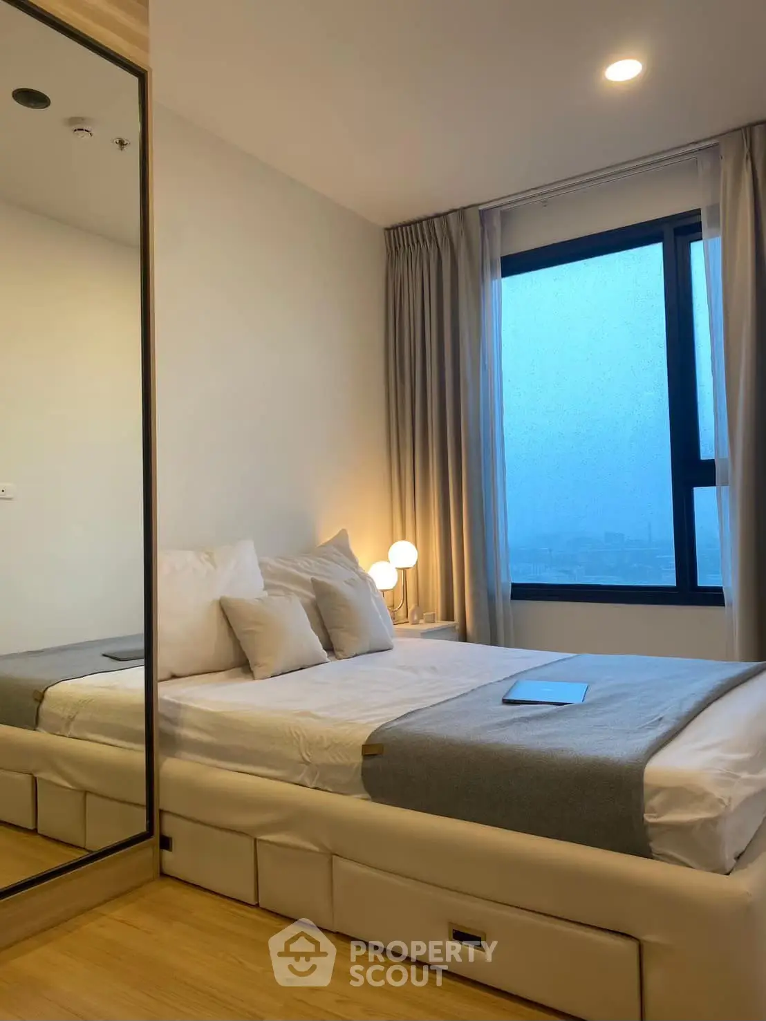 Modern bedroom with large window and cozy lighting