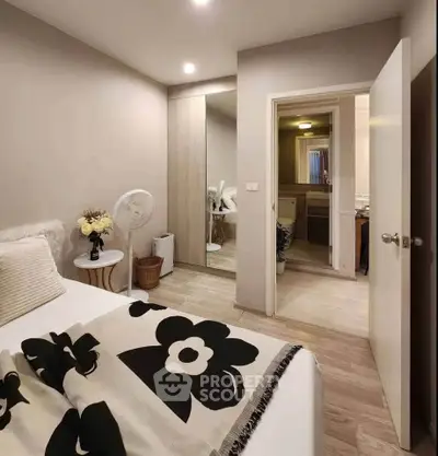 Cozy bedroom with modern decor and ensuite bathroom, featuring elegant floral bedding and soft lighting.