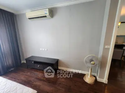 Modern bedroom with air conditioning and wooden flooring in a stylish apartment.