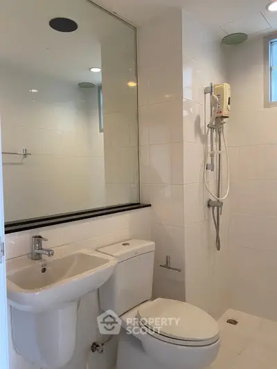 Modern bathroom with sleek white tiles and shower area