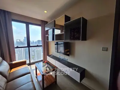 Modern living room with city view, stylish shelving, and comfortable seating in high-rise apartment.