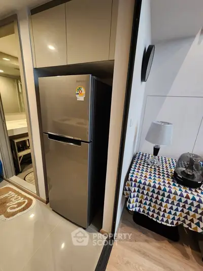 Modern kitchen with sleek fridge and colorful tablecloth, perfect for urban living.