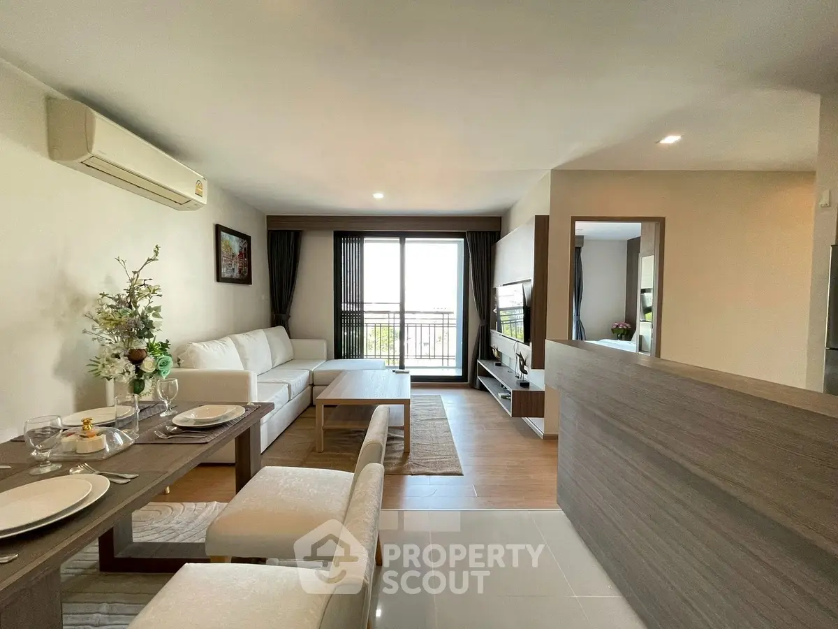 Modern open-plan living room with elegant dining area and balcony view