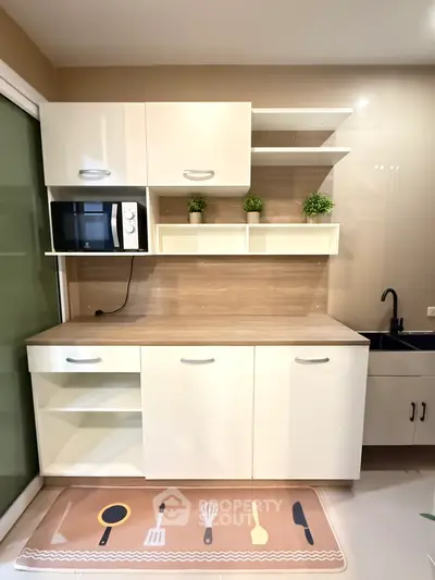 Modern kitchen with sleek cabinets and built-in microwave, featuring a stylish open layout.