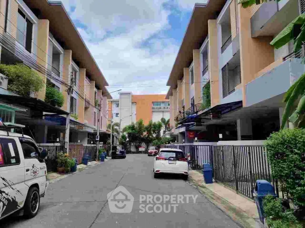 Charming residential street with modern townhouses and lush greenery.