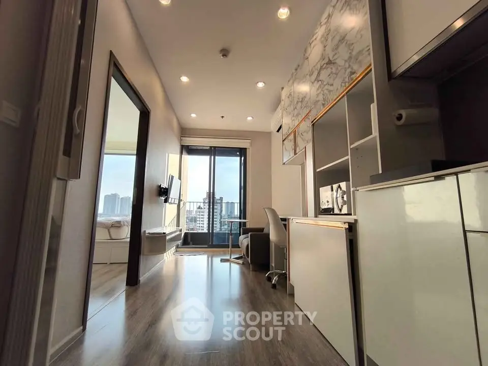 Modern apartment interior with sleek design and city view balcony, featuring open layout and stylish furnishings.