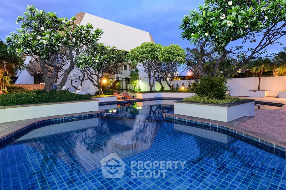 Luxurious outdoor pool area with lush greenery and modern architecture, perfect for relaxation and leisure.