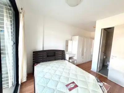 Bright bedroom with large window and modern furniture in a stylish apartment.