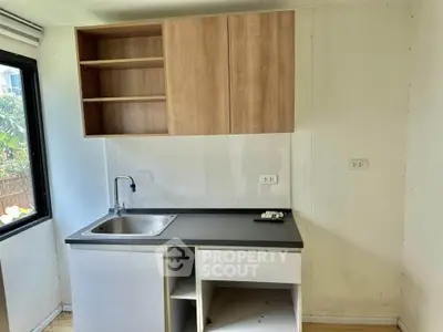 Compact kitchen with modern cabinetry and sink, ideal for small apartments or studio living.