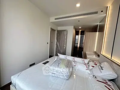 Modern bedroom with stylish decor and ample natural light, featuring a cozy bed and sleek furnishings.