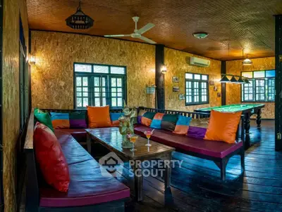 Charming rustic living room with vibrant decor and pool table, perfect for entertainment and relaxation.