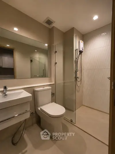 Modern bathroom with glass shower enclosure and sleek fixtures