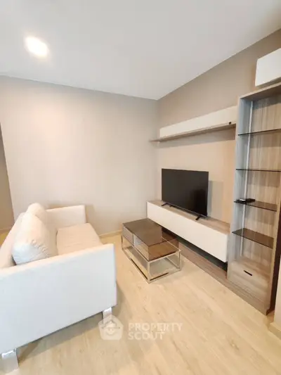 Modern living room with sleek furniture and mounted TV, perfect for relaxation.