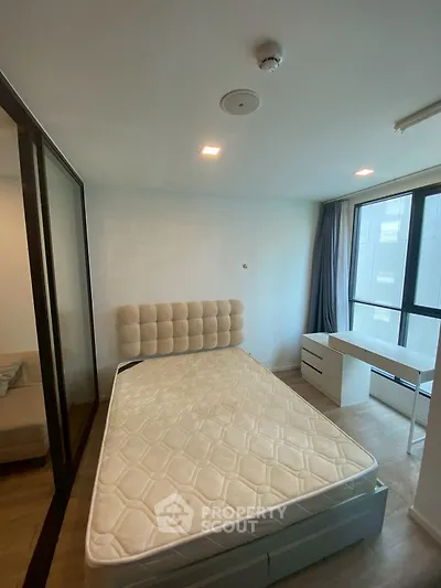 Modern bedroom with large window and minimalist furniture in urban apartment