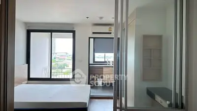 Modern bedroom with balcony view in a stylish apartment, featuring sleek design and ample natural light.