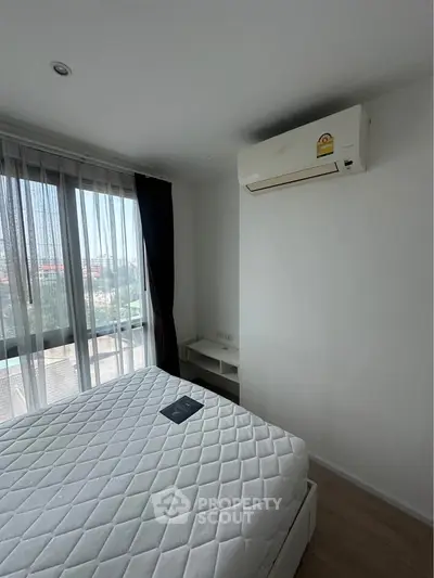 Modern bedroom with large window and air conditioning in a stylish apartment.