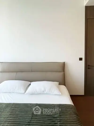Modern bedroom with minimalist design and cozy bedding in a stylish apartment.