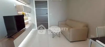 Modern living room with sleek furniture and wall-mounted TV in a stylish apartment.