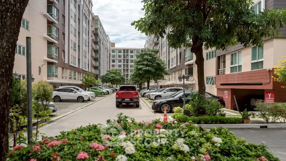 Charming residential complex with lush greenery and ample parking space, ideal for modern living.