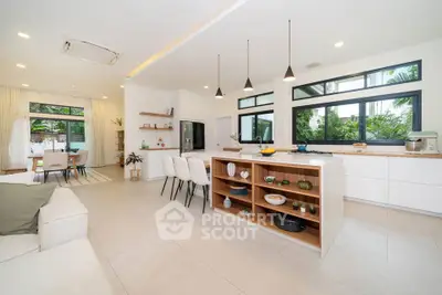 Spacious modern kitchen with open layout and island, featuring large windows and stylish decor.