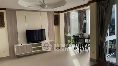 Spacious living room with modern decor and large windows offering natural light and scenic views.