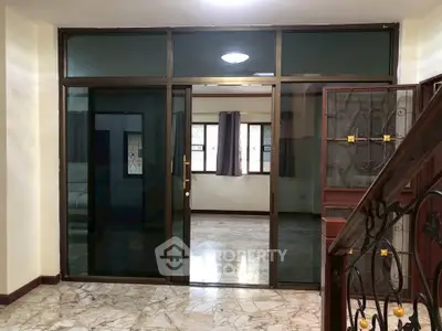 Spacious living room with marble flooring and large windows in a modern apartment.