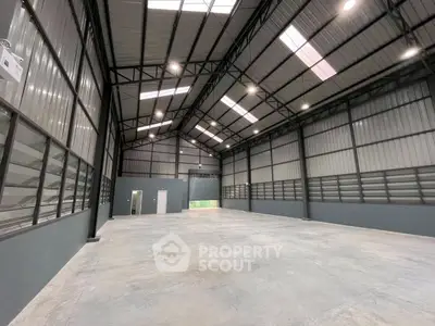 Spacious industrial warehouse with high ceilings and ample natural light.