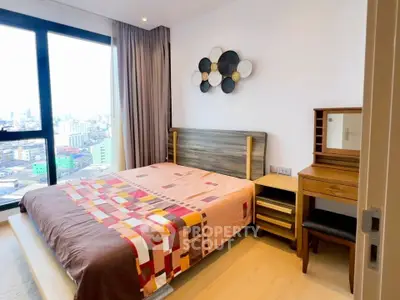 Modern bedroom with city view, featuring stylish decor and natural light.