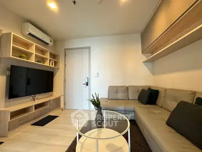 Modern living room with sleek furniture and wall-mounted TV in a cozy apartment.