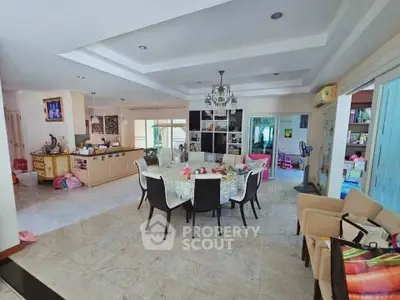 Spacious open-plan living and dining area with elegant chandelier and modern furnishings.