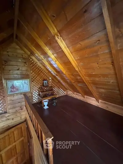 Charming wooden attic space with rustic decor and sloped ceiling