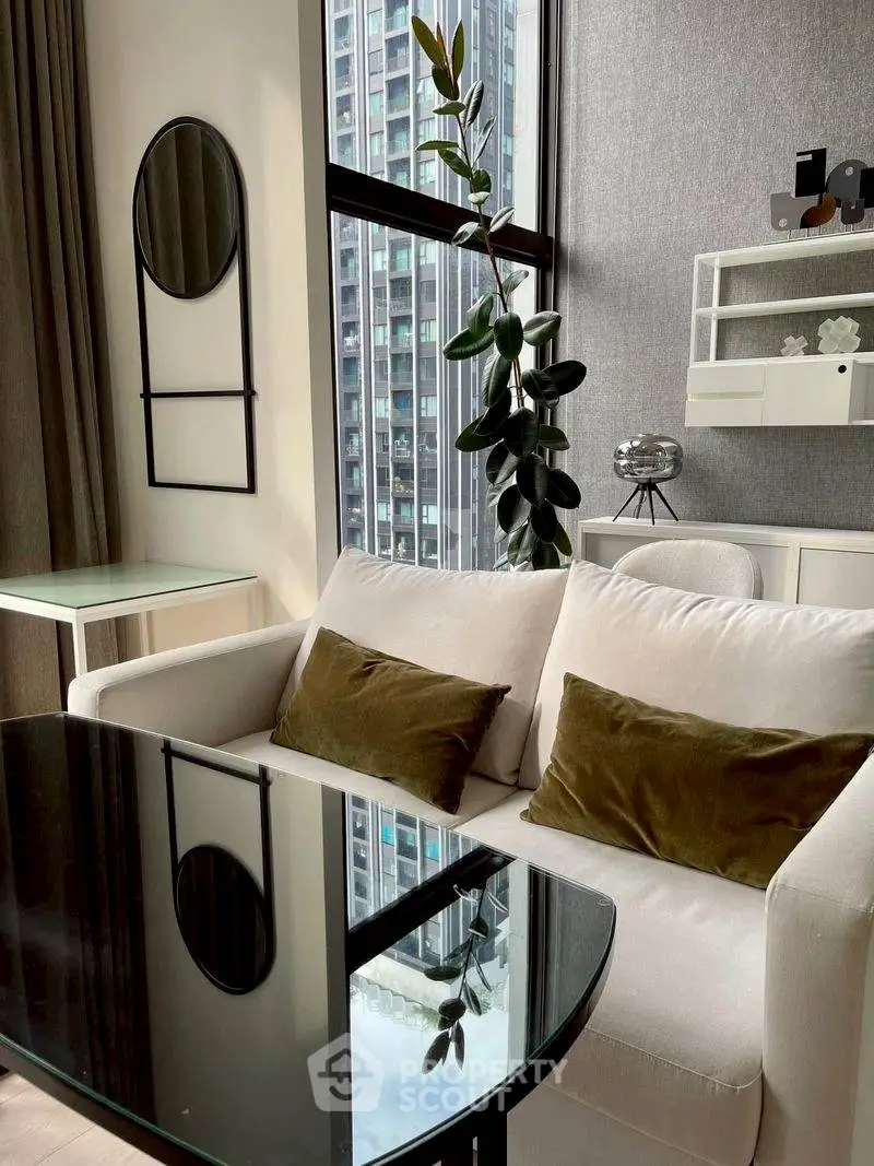 Modern living room with stylish decor and large window view in urban apartment.