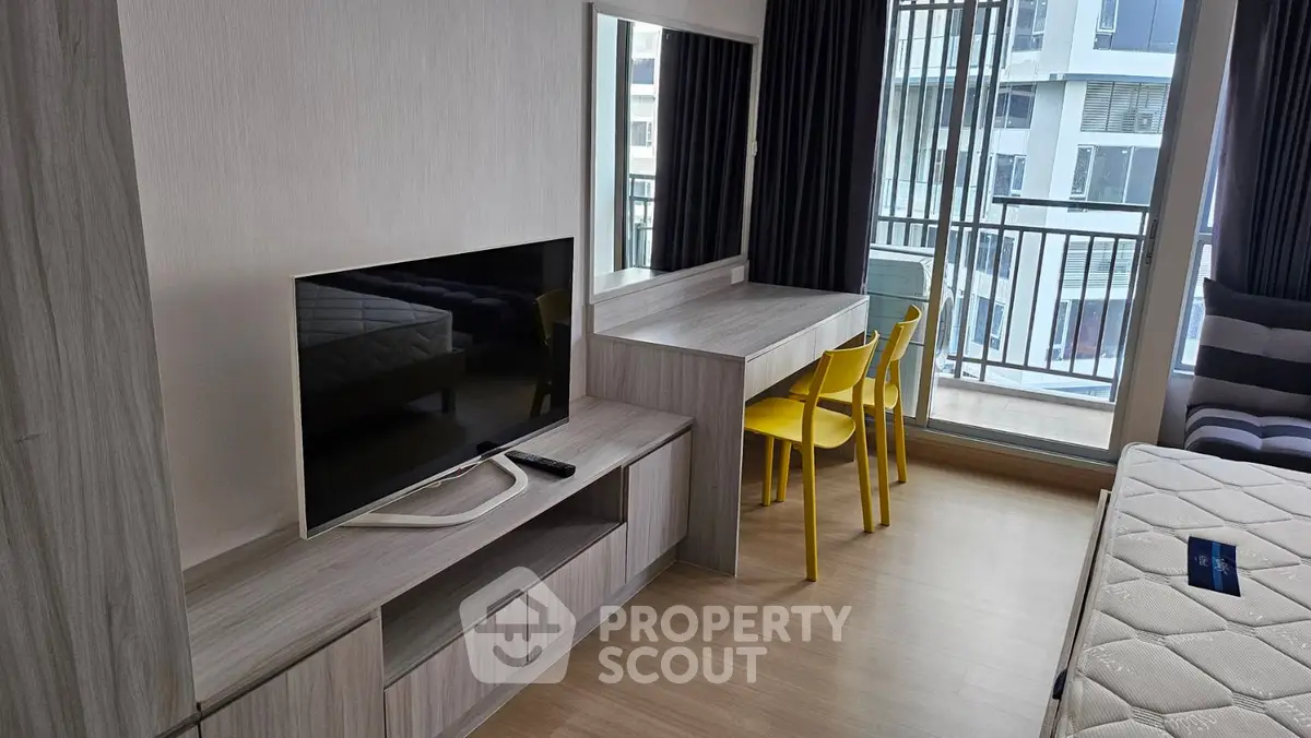 Modern apartment interior with TV, dining area, and balcony view
