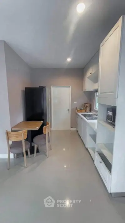 Modern kitchen with sleek cabinetry and dining area in a stylish apartment