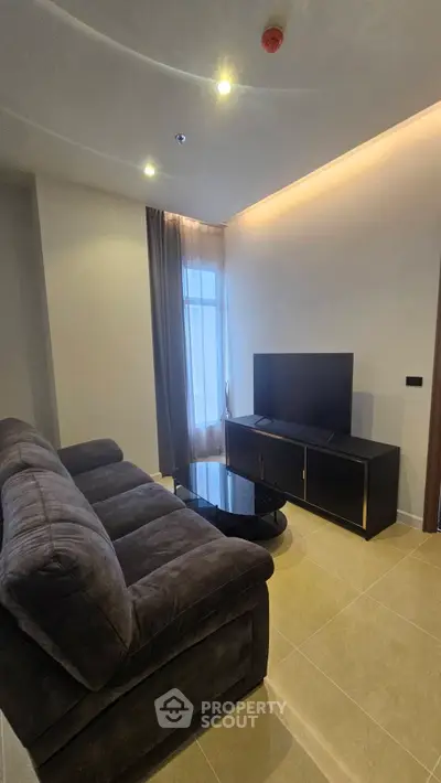 Modern living room with plush sofa and sleek TV stand, ideal for cozy relaxation.