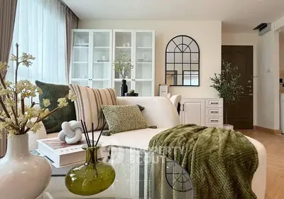 Stylish living room with modern decor and cozy green accents, perfect for relaxation and entertaining.