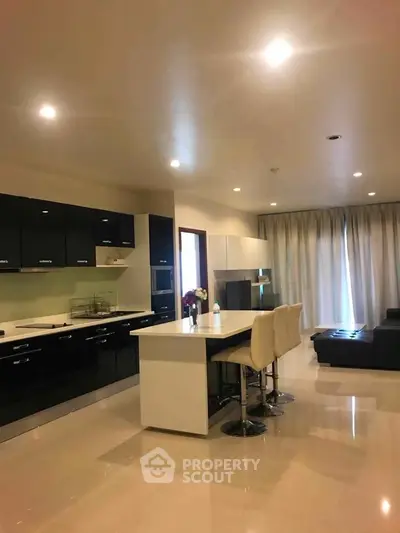 Modern open-layout kitchen with sleek black cabinets and island seating
