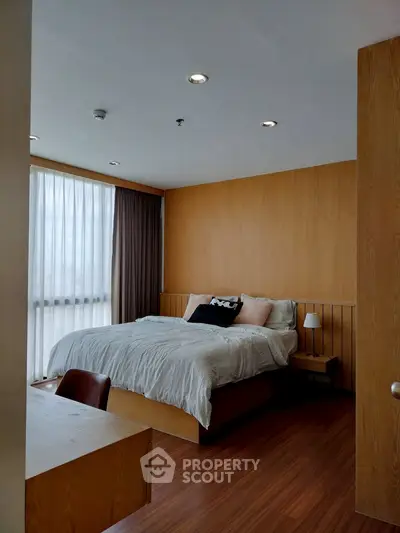 Modern bedroom with wooden accents and large window for natural light